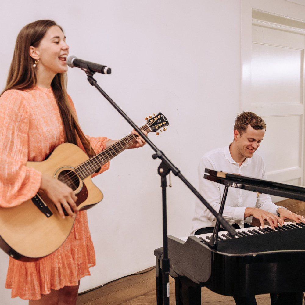 "Zangeres, zanger, pianist en gitarist brengen samen muziek tijdens een kerkdienst."