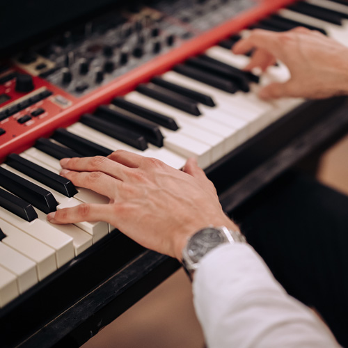"Pianist bespeelt de piano met zorgvuldige aandacht tijdens een kerkdienst."